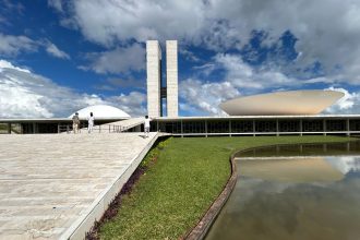 Vista externa do Congresso Nacional do Brasil, com suas cúpulas e edifícios sob um céu claro.