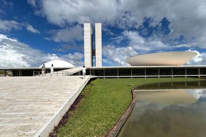 Vista externa do Congresso Nacional do Brasil, com suas cúpulas e edifícios sob um céu claro.
