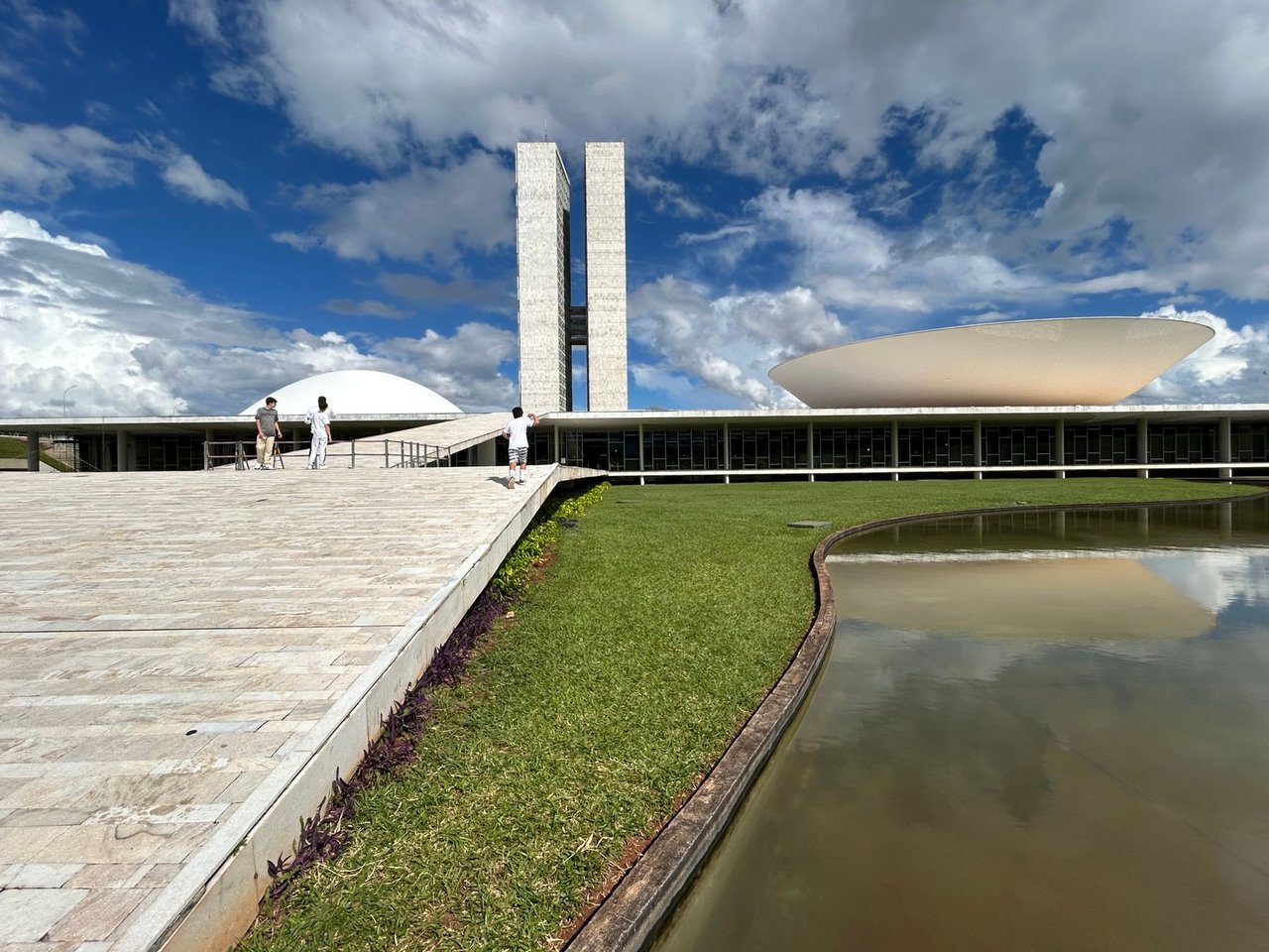 Vista externa do Congresso Nacional do Brasil, com suas cúpulas e edifícios sob um céu claro.